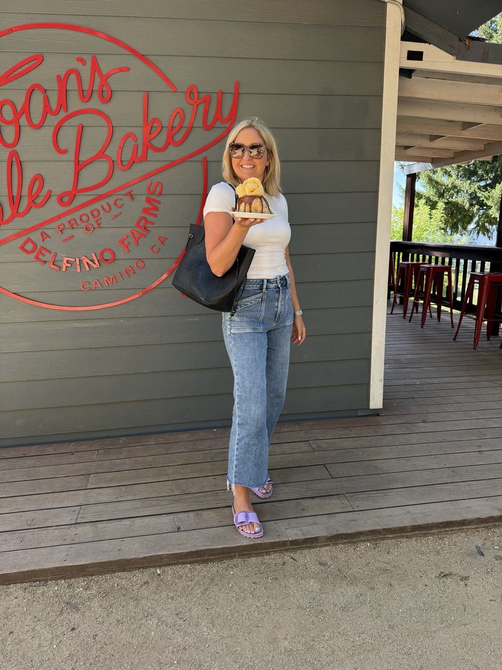 Adele outside a bakery holding a treat