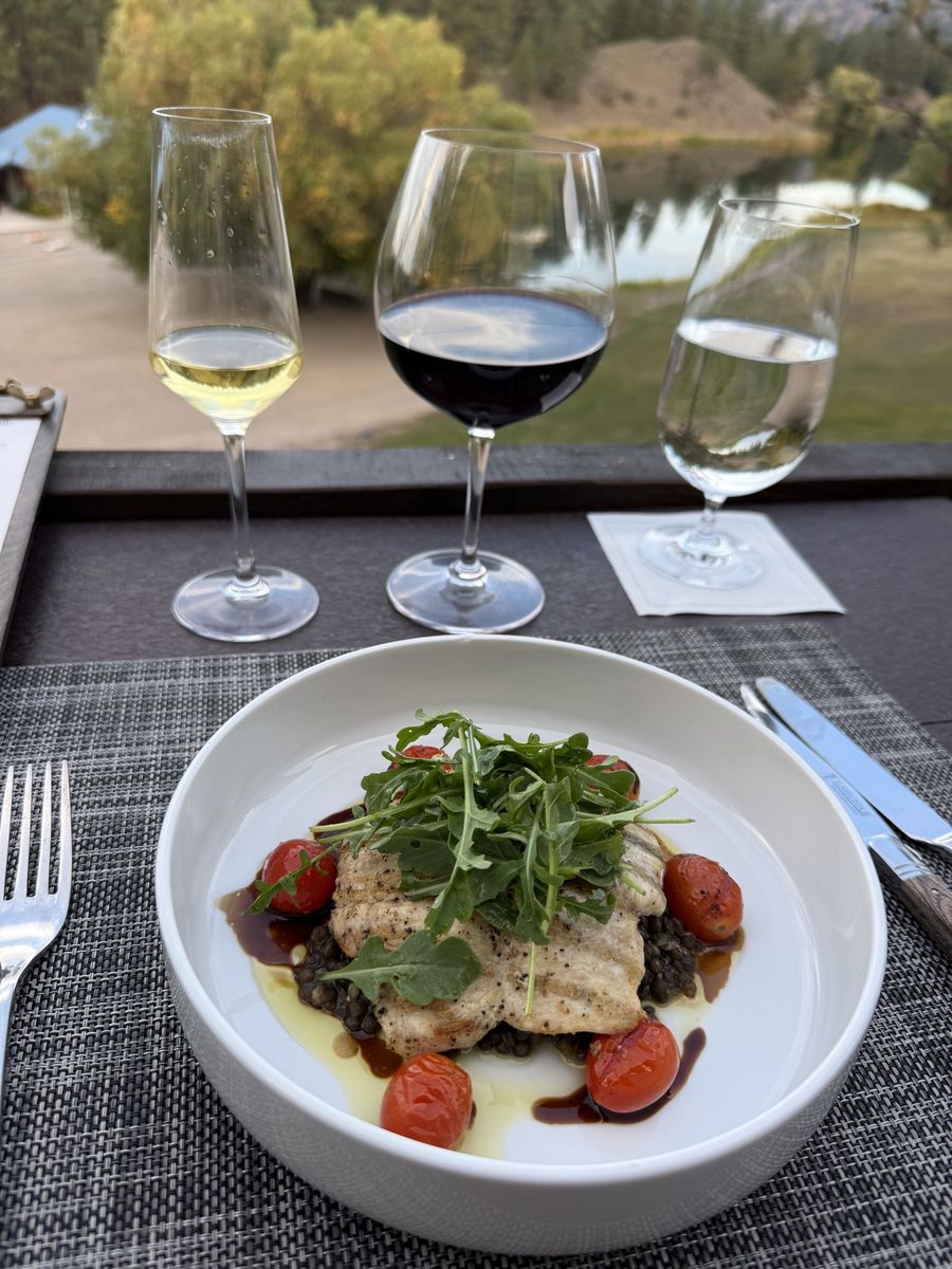 Dinner plate with wine glasses and the lake view behind at Riverview Ranch